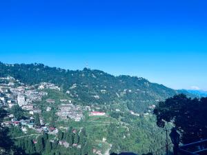 a view of a mountain with houses and trees at Irish Town Mussoorie in Mussoorie