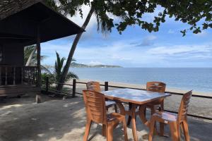 a table and chairs sitting next to the beach at Sea Breeze Bungalow in Lamai