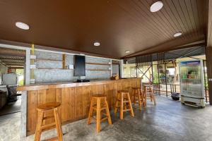 a bar with wooden bar stools and a tv at Sea Breeze Bungalow in Lamai
