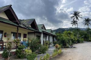 a row of houses with palm trees in the background at Sea Breeze Bungalow in Lamai