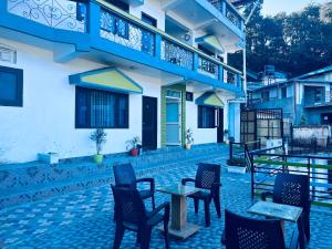 a patio with chairs and tables in front of a building at Irish Town Mussoorie in Mussoorie