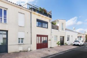 une maison avec une porte rouge dans une rue dans l'établissement Loft contemporain à 2 pas du centre, à Bordeaux