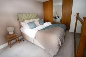 a bedroom with a large bed and a mirror at Seafront Cottage - The Nook in Cardiff