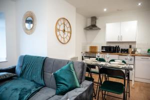a living room with a couch and a table with chairs at Bv Charming 2-Bedroom Apartment by Kirkstall Shopping Centre, Free Parking in Leeds