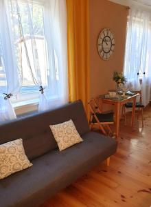 un soggiorno con divano, tavolo e orologio. di Apartmán CENTRAL, self check in 24 h a Banská Bystrica