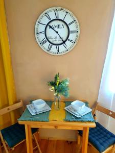 tavolo con orologio sul muro e tavolo con sedie di Apartmán CENTRAL, self check in 24 h a Banská Bystrica