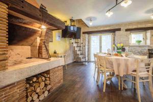 a dining room with a table with chairs and a fireplace at Holiday Home Gašparini in Višnjan