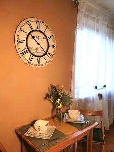 une horloge accrochée au mur au-dessus d'une table dans l'établissement Apartmán CENTRAL, self check in 24 h, à Banská Bystrica