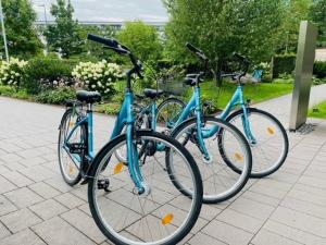 tre biciclette parcheggiate l'una accanto all'altra su un marciapiede di Motel One Berlin-Bellevue a Berlino