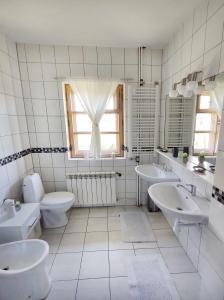 a white bathroom with two sinks and a toilet at Na Bugaju in Czarny Dunajec