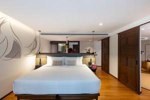 a bedroom with a large white bed in a room at Hotel Sensai Nimman Chiang Mai - Adults Only in Chiang Mai