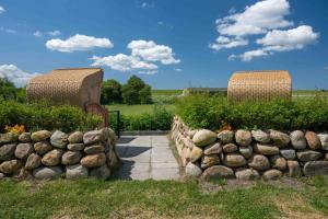 a garden with a stone wall and a walkway at Ferienwohnung Rüm Hart in Hattstedtermarsch +2 photos