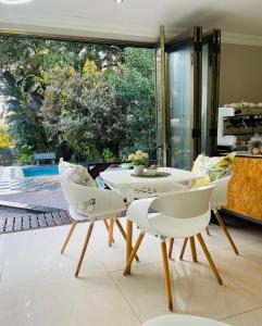 a dining room with a table and chairs and a window at RRT Retreat Oasis in Pretoria