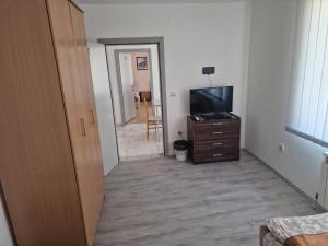 a hallway with a television and a dresser in a room at Hotel Saradis in Kruševac