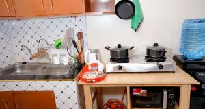 a kitchen counter with two pots on a stove at Shalom Apartments in Naivasha