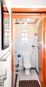 a bathroom with a toilet and a window at Shalom Apartments in Naivasha