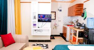 a living room with a couch and a kitchen at Shalom Apartments in Naivasha