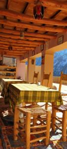 a table and chairs in a room with a wooden ceiling at Gite Atlas Toubkal in Imlil