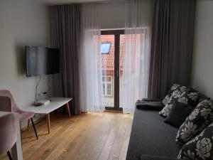 - un salon avec un canapé, une table et une fenêtre dans l'établissement Lutsu 12 Apartment - Self check-in, à Tartu