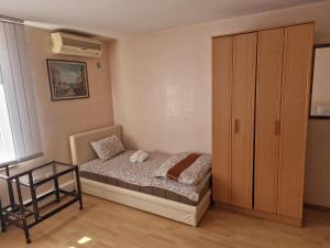 a small bedroom with a bed and a cabinet at Hotel Saradis in Kruševac