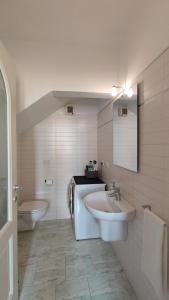 uma casa de banho com 2 lavatórios e um WC em BLA BLA in centro em Levico Terme