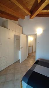 um quarto com armários brancos e uma cama num quarto em BLA BLA in centro em Levico Terme