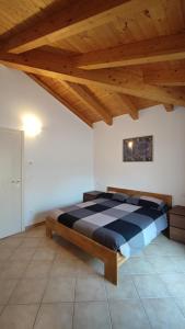uma cama num quarto com tecto em madeira em BLA BLA in centro em Levico Terme