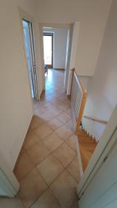 a hallway with a staircase and a tiled floor at BLA BLA in centro in Levico Terme