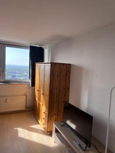 uma sala de estar com televisão e uma grande janela em Ferienwohnung in Köln 2910 em Colônia