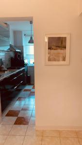 a kitchen with a painting on a wall at Urban Sunset Loft in Bucharest