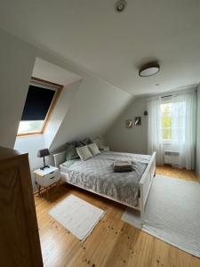 a white bedroom with a bed and a window at Kivika in Lahe