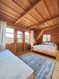 a bedroom with two beds and a wooden ceiling at Na Bugaju in Czarny Dunajec