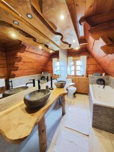 La salle de bains est pourvue de 2 lavabos et d'un grand plafond en bois. dans l'établissement Na Bugaju, à Czarny Dunajec