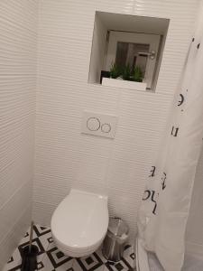 uma casa de banho branca com um WC e um espelho. em Katarina em Sveti Filip i Jakov