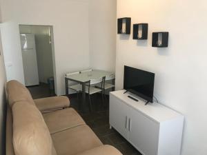 uma sala de estar com um sofá, uma televisão e uma mesa em Piedra de la Rendona 2 em Conil de la Frontera