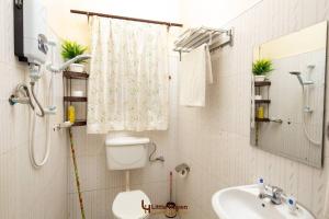 a bathroom with a shower and a toilet and a sink at Little Haven in Fort Portal