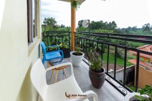 a balcony with a white bench and some plants at Little Haven in Fort Portal