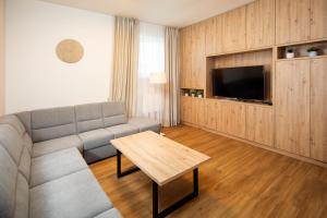 a living room with a couch and a table at Hotel Granit Smrekovica in Liptovská Osada