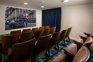 a room with chairs and a picture of a man at Hotel Granit Smrekovica in Liptovská Osada