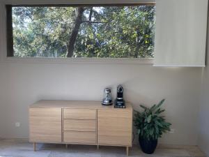 uma cómoda de madeira num quarto com uma janela em La Canopée Private Lodge em Nîmes