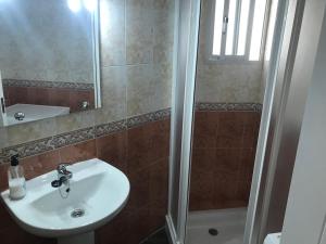 uma casa de banho com um lavatório e um chuveiro em Piedra de la Rendona 2 em Conil de la Frontera