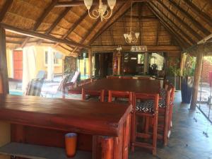 a restaurant with a large wooden table and chairs at One & Only Bush Lodge in Bela-Bela