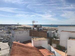 uma vista sobre os telhados dos edifícios e o oceano em Piedra de la Rendona 2 em Conil de la Frontera