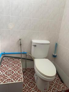 a bathroom with a toilet and a tile floor at RC Apartment in Krabi