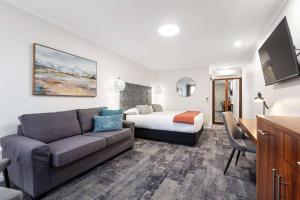 Habitación de hotel con sofá y cama en Comfort Inn Deakin Palms, en Mildura