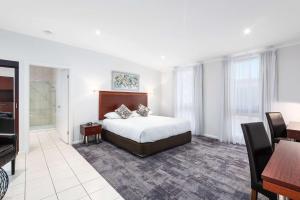 a bedroom with a bed and a desk and a table at Comfort Inn Deakin Palms in Mildura
