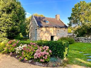 an old stone house with flowers in front of it at Ker Bara in La Trinité-sur-Mer