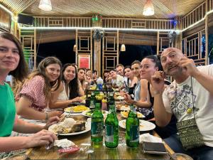 寧平的住宿－HoangLong Riverside Homestay，一群坐在餐桌旁吃饭的人