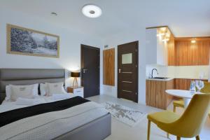 ein Schlafzimmer mit Bett und Tisch und eine Küche in der Unterkunft Apartamenty Płomnica in Karpacz