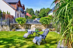 eine Terrasse mit Tisch und Stühlen in einem Hof in der Unterkunft Apartamenty Płomnica in Karpacz